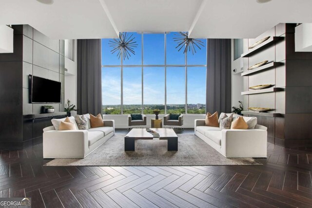 living area featuring a towering ceiling, dark wood-style flooring, and a wealth of natural light