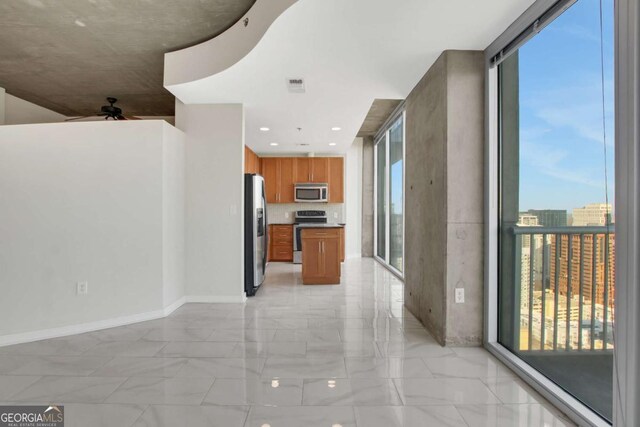 empty room featuring floor to ceiling windows and baseboards