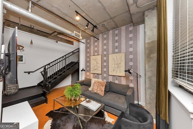 living area featuring stairway, visible vents, wood finished floors, and rail lighting