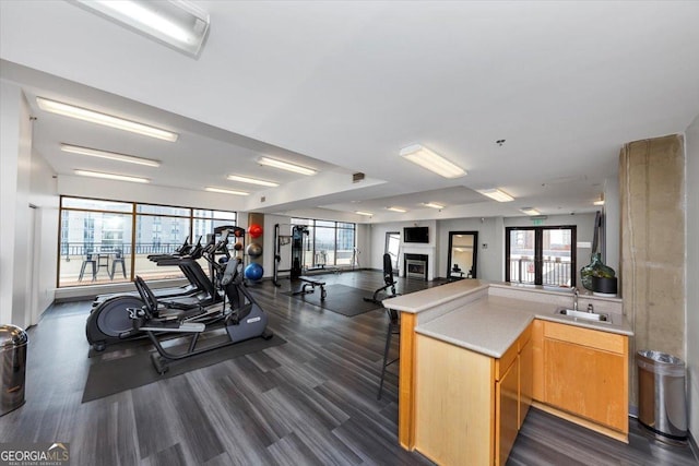 exercise room with a glass covered fireplace and a sink