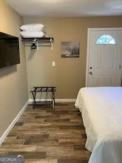 bedroom with baseboards and wood finished floors