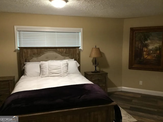 bedroom with wood finished floors, baseboards, and a textured ceiling