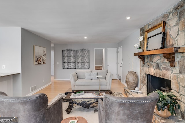 living area with visible vents, recessed lighting, a fireplace, and wood finished floors