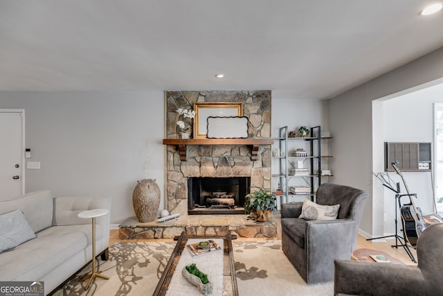 living area featuring baseboards, recessed lighting, a stone fireplace, and wood finished floors