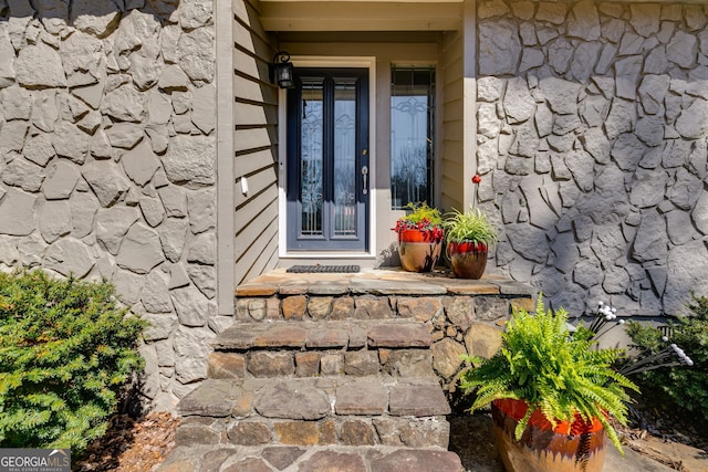 property entrance featuring stone siding
