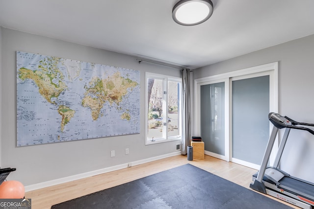 workout room featuring wood finished floors and baseboards