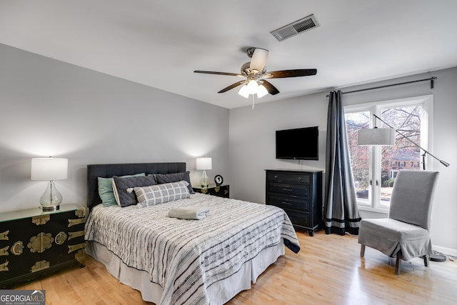 bedroom featuring a ceiling fan, visible vents, and light wood-type flooring