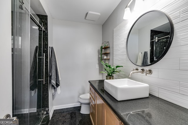 bathroom with vanity, toilet, baseboards, and a stall shower