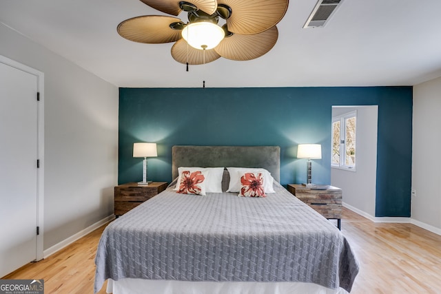 bedroom with visible vents, baseboards, ceiling fan, and wood finished floors