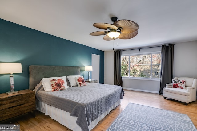 bedroom featuring ceiling fan, baseboards, and wood finished floors