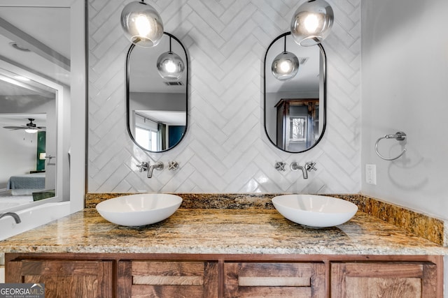 ensuite bathroom featuring decorative backsplash, visible vents, and a sink