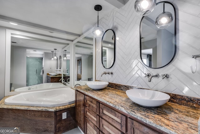 full bath featuring double vanity, a tub with jets, backsplash, and a sink