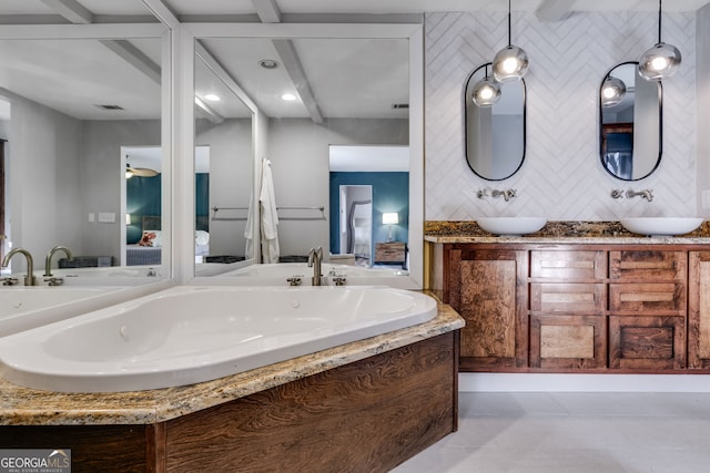 ensuite bathroom with double vanity, a jetted tub, visible vents, and a sink