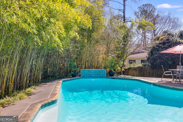 view of swimming pool with a patio, a fenced in pool, and fence