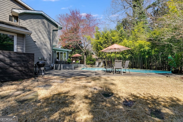 view of yard featuring an outdoor pool and a patio