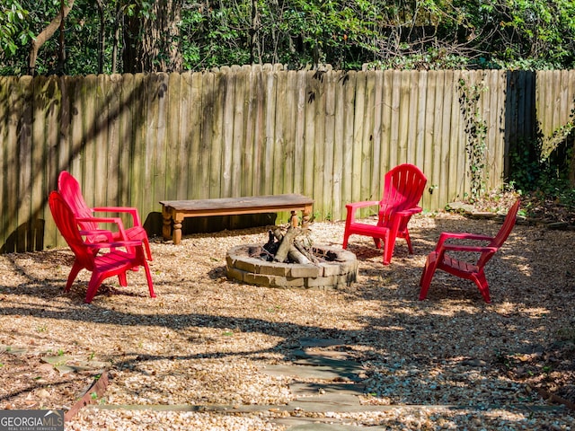 view of yard featuring an outdoor fire pit and fence