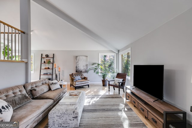 living area with baseboards, lofted ceiling with beams, and wood finished floors