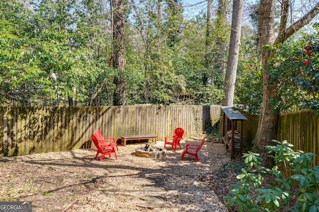 view of playground with a fire pit and a fenced backyard