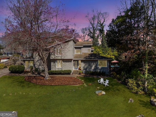 view of front of house with stone siding and a front lawn