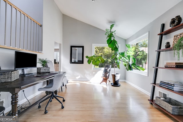 office space with baseboards, high vaulted ceiling, and wood finished floors