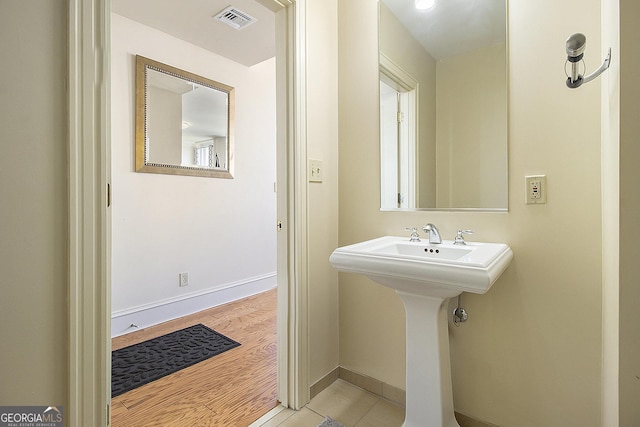 bathroom featuring visible vents, baseboards, and wood finished floors