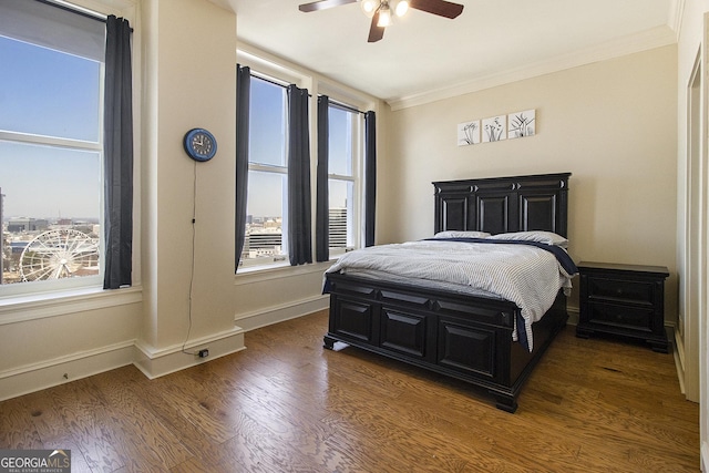 bedroom with ceiling fan, crown molding, baseboards, and wood finished floors