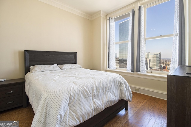 bedroom featuring ornamental molding and dark wood-style flooring