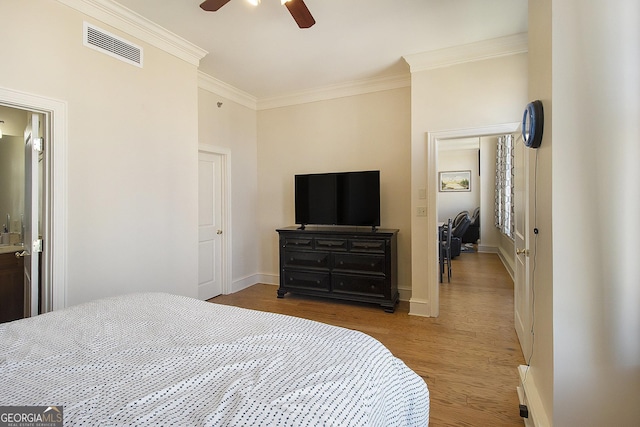 bedroom featuring visible vents, ceiling fan, baseboards, ornamental molding, and wood finished floors