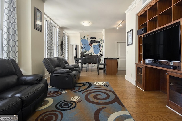 living room featuring crown molding, wine cooler, baseboards, and light wood-type flooring