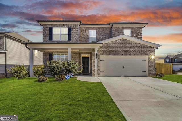 view of front of house featuring a front yard, fence, an attached garage, concrete driveway, and brick siding