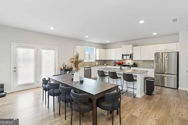 dining area featuring recessed lighting, visible vents, and light wood-style floors