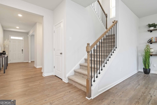 foyer featuring recessed lighting, light wood-type flooring, baseboards, and stairs