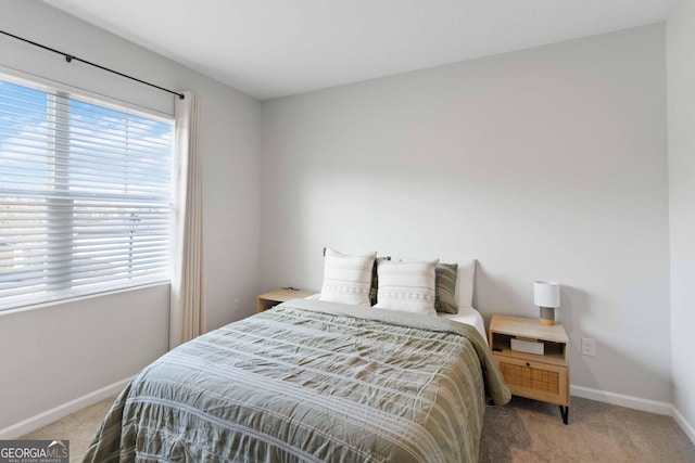 bedroom with multiple windows, baseboards, and carpet floors