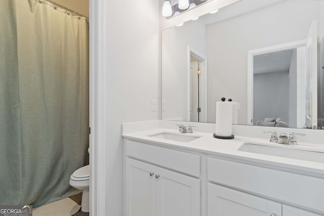 bathroom with double vanity, toilet, a shower with curtain, and a sink