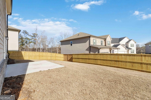 view of yard with a residential view, a patio, and a fenced backyard