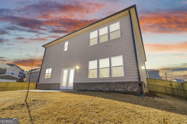 back of house featuring a lawn and fence