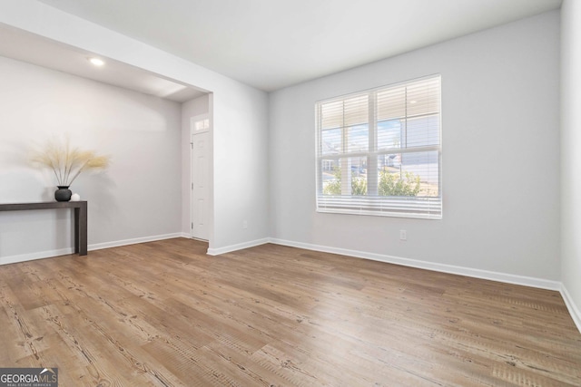 spare room featuring wood finished floors and baseboards