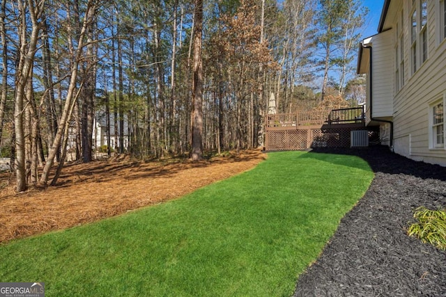 view of yard with a deck and central AC unit