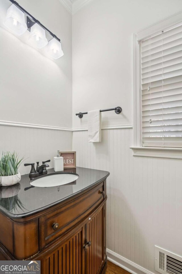 bathroom with a wainscoted wall, vanity, and visible vents