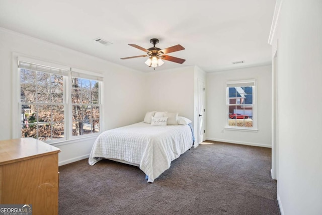 bedroom featuring visible vents, dark carpet, and multiple windows