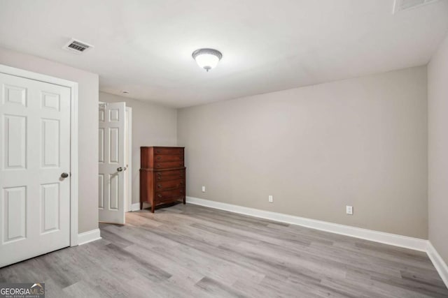 unfurnished bedroom featuring wood finished floors, visible vents, and baseboards