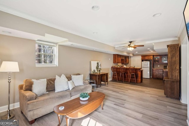 living area featuring light wood finished floors, crown molding, baseboards, ceiling fan, and recessed lighting