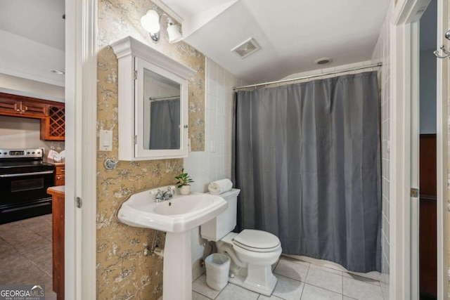 full bath featuring a shower with curtain, visible vents, a sink, tile patterned flooring, and toilet