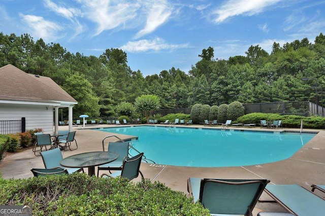 community pool featuring a patio and fence