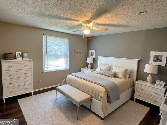 bedroom featuring dark wood-style floors, baseboards, a textured ceiling, and a ceiling fan