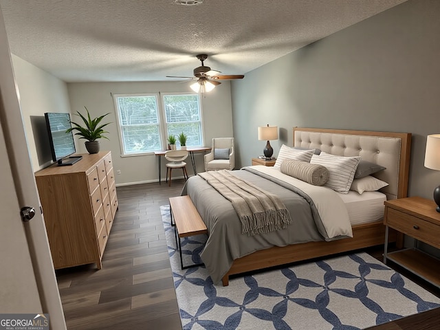 bedroom with a ceiling fan, wood finished floors, baseboards, and a textured ceiling