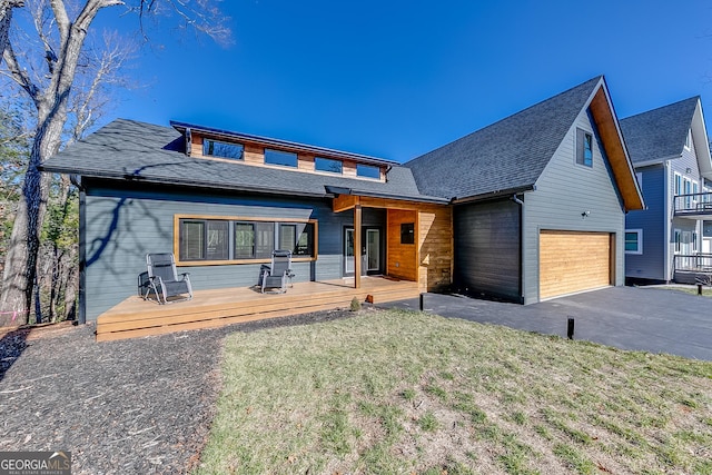 view of front of house with aphalt driveway, a wooden deck, a front yard, and a shingled roof