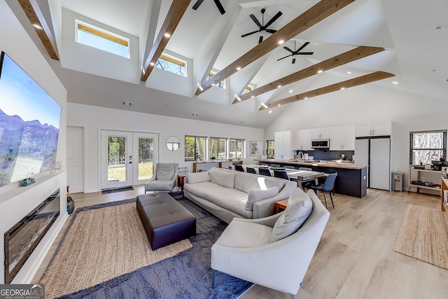 living area with visible vents, beamed ceiling, light wood-style flooring, french doors, and high vaulted ceiling