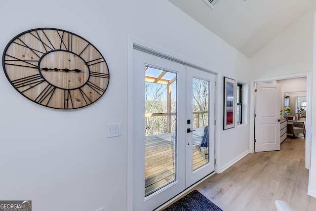 doorway with light wood-type flooring, visible vents, french doors, baseboards, and vaulted ceiling