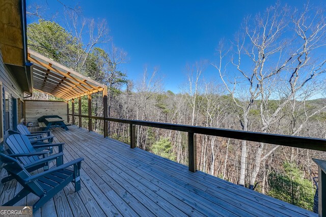 wooden deck featuring a view of trees